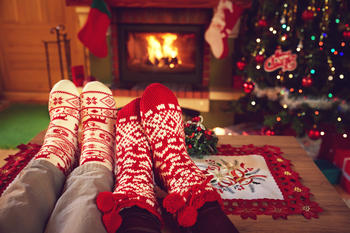 føtter på bordet med julesokker foran peisen (bilde Shutterstock_534208825)