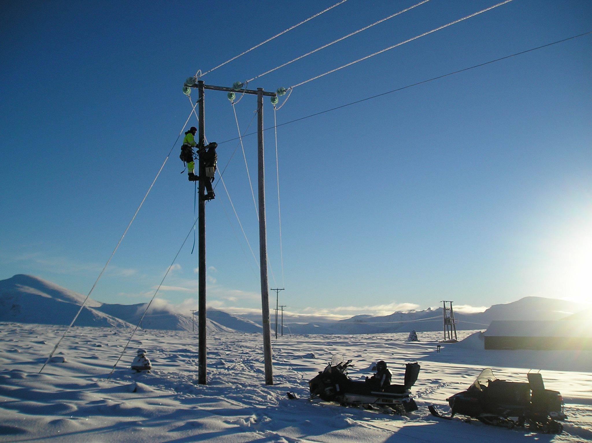 Energimontører i høyspentstolpe - vinterlandskap